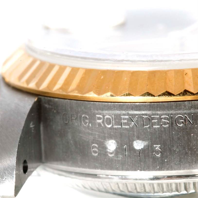 This image shows a close-up of the side view of a Rolex Datejust 69173 Women's Stainless Steel Champagne Dial 69173 Women's Stainless Steel Champagne Dial watch, highlighting the engraved serial number and part of the bezel.