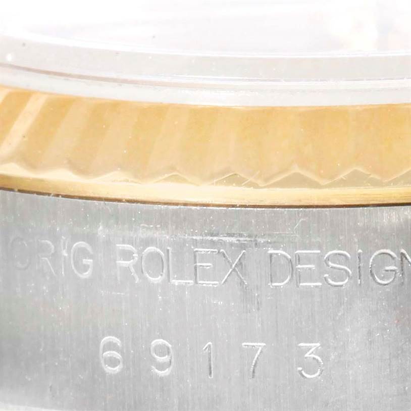 The image shows a close-up of the engraved serial and model number along with the fluted bezel of a Rolex Datejust 69173 Women's Stainless Steel Champagne Dial 69173 Women's Stainless Steel Champagne Dial watch.