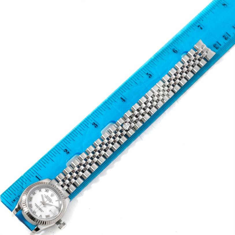 The image depicts a Rolex Datejust 179174 Women's Stainless Steel White Dial 179174 Women's Stainless Steel White Dial watch laid flat, with its bracelet aligned next to a ruler for measurement.