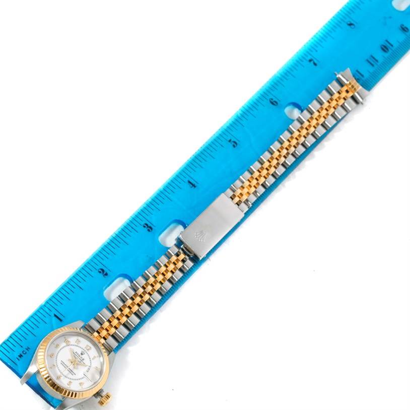 The image shows a Rolex Datejust 69173 Women's Stainless Steel White Dial 69173 Women's Stainless Steel White Dial watch laid flat with its band extended next to a blue ruler for measurement.