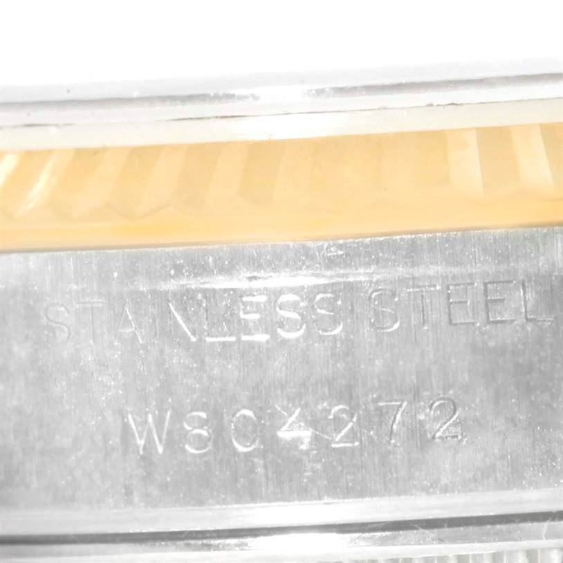 This is a close-up of the Rolex Datejust 69173 Women
s Stainless Steel Champagne Dial 69173 Women
s Stainless Steel Champagne Dial
s side, showing part of the fluted bezel and case with "STAINLESS STEEL" engraved.