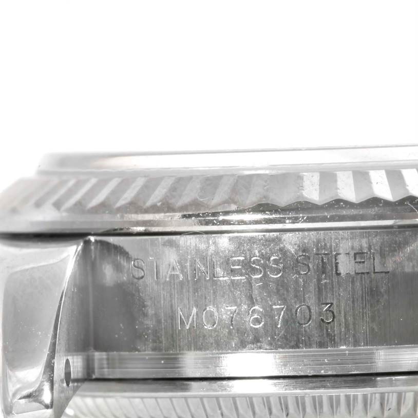 This close-up image shows the side view of the bezel and case of the Rolex Datejust 179174 Women's Stainless Steel Mother of Pearl Dial 179174 Women's Stainless Steel Mother of Pearl Dial watch, featuring "STAINLESS STEEL" engraving with a serial number.