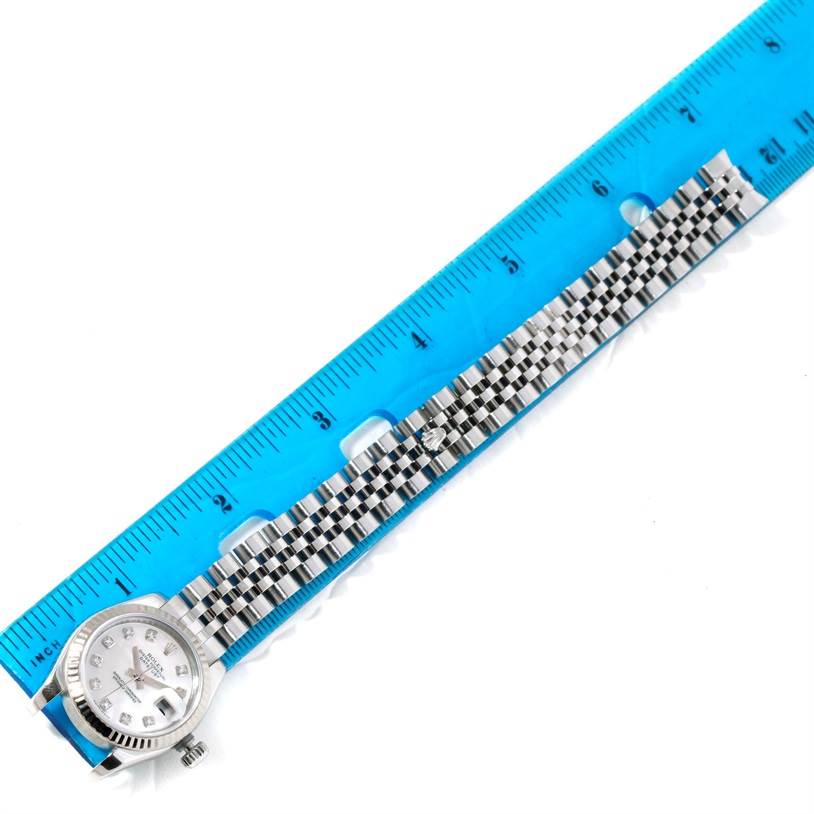 The image shows a Rolex Datejust 179174 Women's Stainless Steel Mother of Pearl Dial 179174 Women's Stainless Steel Mother of Pearl Dial watch laid flat next to a ruler, displaying its face and metal bracelet.