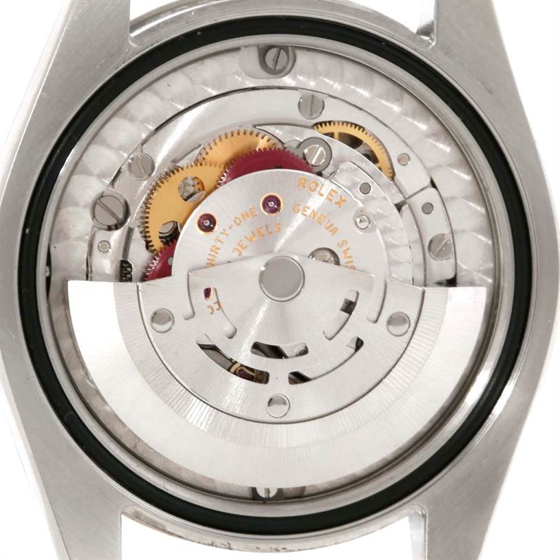 The image shows the backside of a Mid-Size Rolex watch, displaying its mechanical movement.