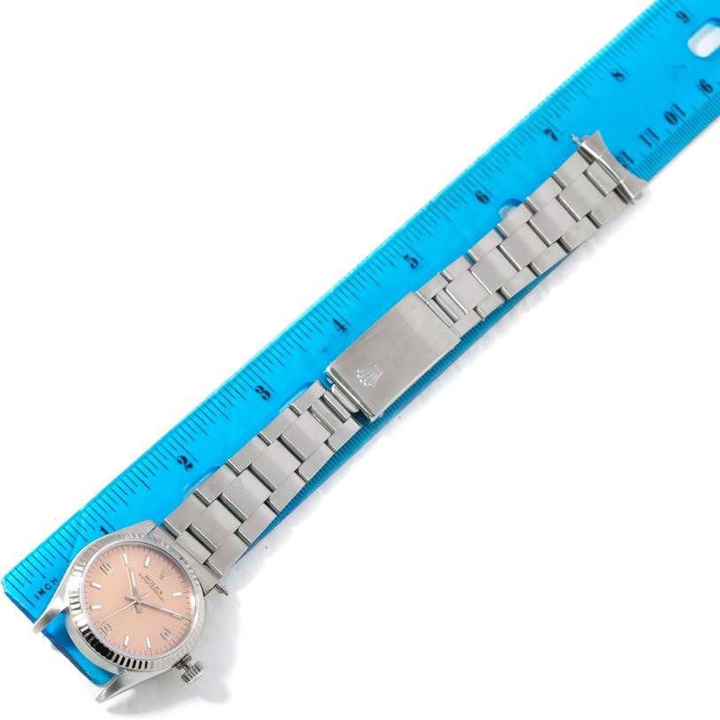 The Rolex Mid-Size 67514 Women's Stainless Steel Pink Dial 67514 Women's Stainless Steel Pink Dial watch is shown lying flat against a ruler, displaying its entire bracelet and face.