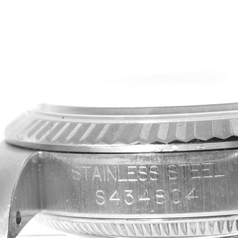 This close-up image of the Rolex Mid-Size 67514 Women's Stainless Steel Pink Dial 67514 Women's Stainless Steel Pink Dial model shows the side of the watch case, highlighting the bezel and engraved serial number.