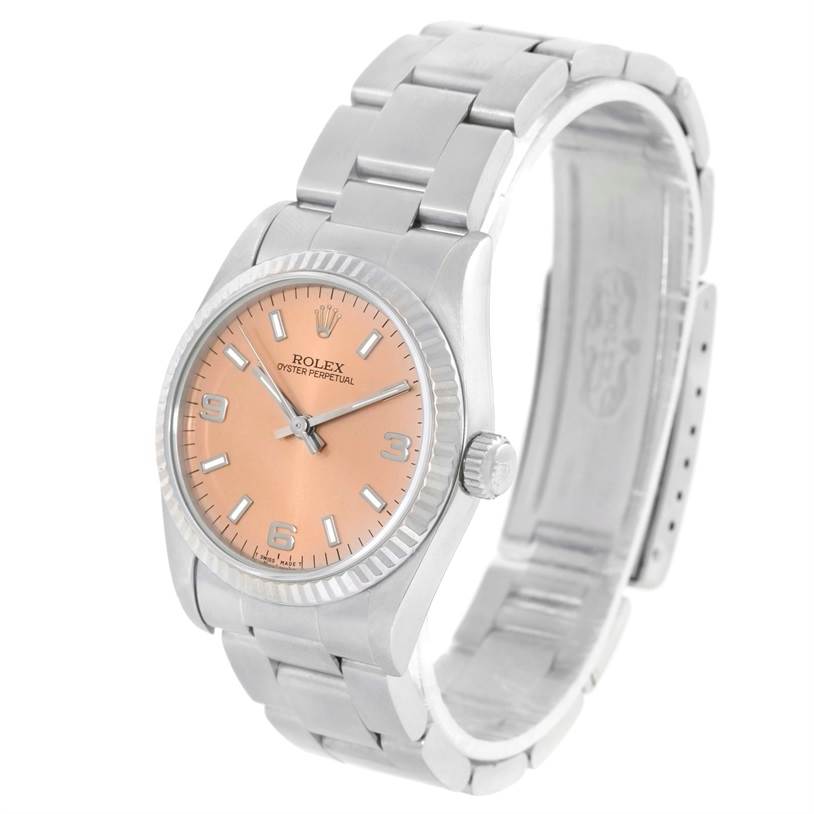 This image shows a Rolex Mid-Size 67514 Women's Stainless Steel Pink Dial 67514 Women's Stainless Steel Pink Dial Oyster Perpetual watch at a three-quarter angle, highlighting its face, bezel, and bracelet.
