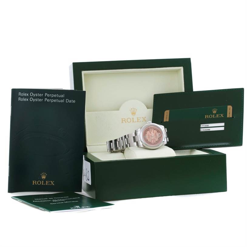 The image shows a Mid-Size Rolex watch with a pink dial in its box, accompanied by manuals and a warranty card.