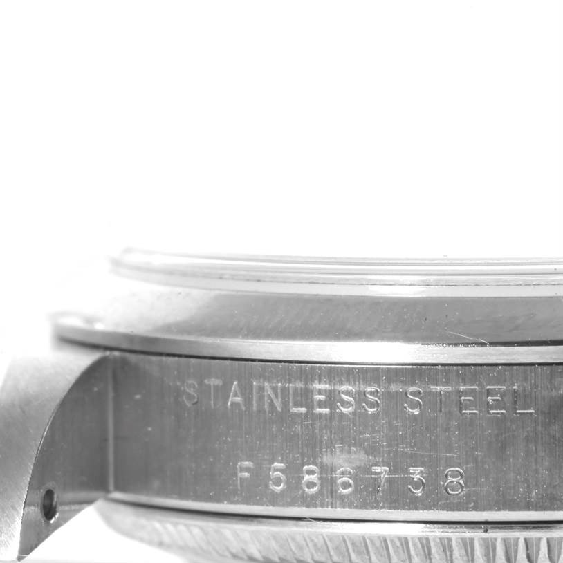 The image shows a close-up of the side of a Rolex Mid-Size 77080 Women's Stainless Steel Black Dial 77080 Women's Stainless Steel Black Dial model watch, highlighting the serial number and stainless steel case.