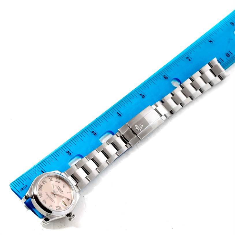 This image shows a Rolex Mid-Size 178240 Women's Stainless Steel Pink Dial 178240 Women's Stainless Steel Pink Dial watch with a metal bracelet placed next to a blue ruler for measurement.