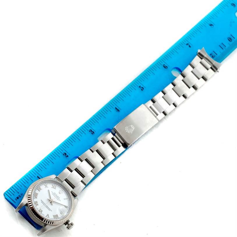 The image shows a Rolex Mid-Size 78274 Women's Stainless Steel White Dial 78274 Women's Stainless Steel White Dial watch laid flat next to a ruler, showcasing the face, bracelet, and clasp.