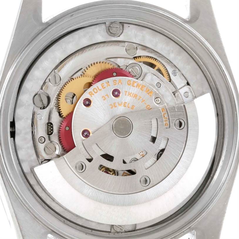 The image shows the internal mechanical movement of a Mid-Size Rolex watch from the back angle, highlighting gears and jewels.