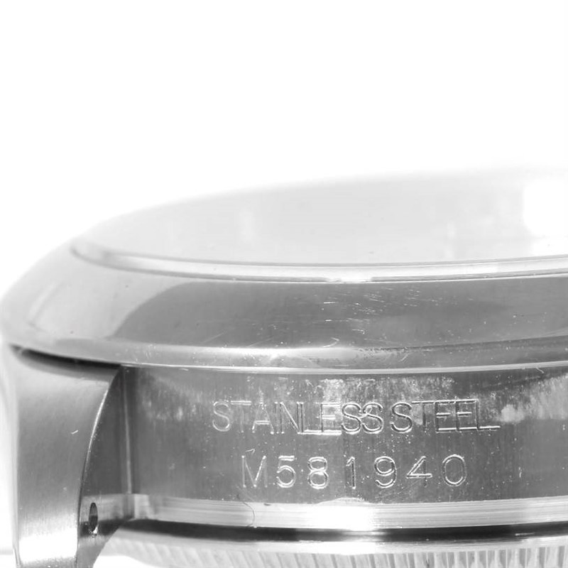 The image shows the side view of a Rolex Mid-Size watch's stainless steel case back with its serial number.