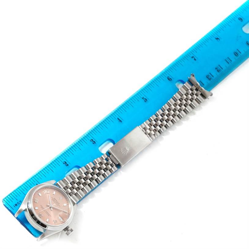 The image shows a Rolex Mid-Size 78240 Women's Stainless Steel Pink Dial 78240 Women's Stainless Steel Pink Dial model watch with a pink dial and metal bracelet, placed next to a blue ruler for scale.