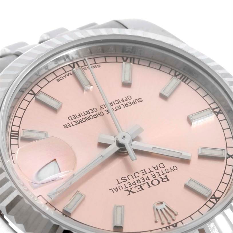 The image shows a close-up of a Rolex Mid-Size 178274 Women's Stainless Steel Pink Dial 178274 Women's Stainless Steel Pink Dial watch face with a pink dial and silver hour markers, including the magnified date window.