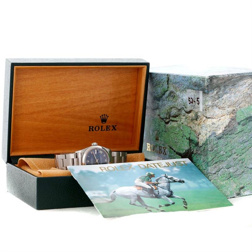 The Rolex Mid-Size 68240 Women's Stainless Steel Blue Dial 68240 Women's Stainless Steel Blue Dial watch is shown partially inside its open box alongside the outer box and a Rolex Datejust booklet.