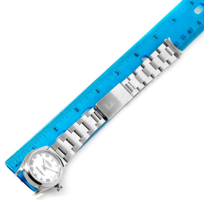 The image shows a Rolex Mid-Size 68240 Women's Stainless Steel White Dial 68240 Women's Stainless Steel White Dial watch, viewed from the top, including the face and the entire bracelet laid beside a ruler.