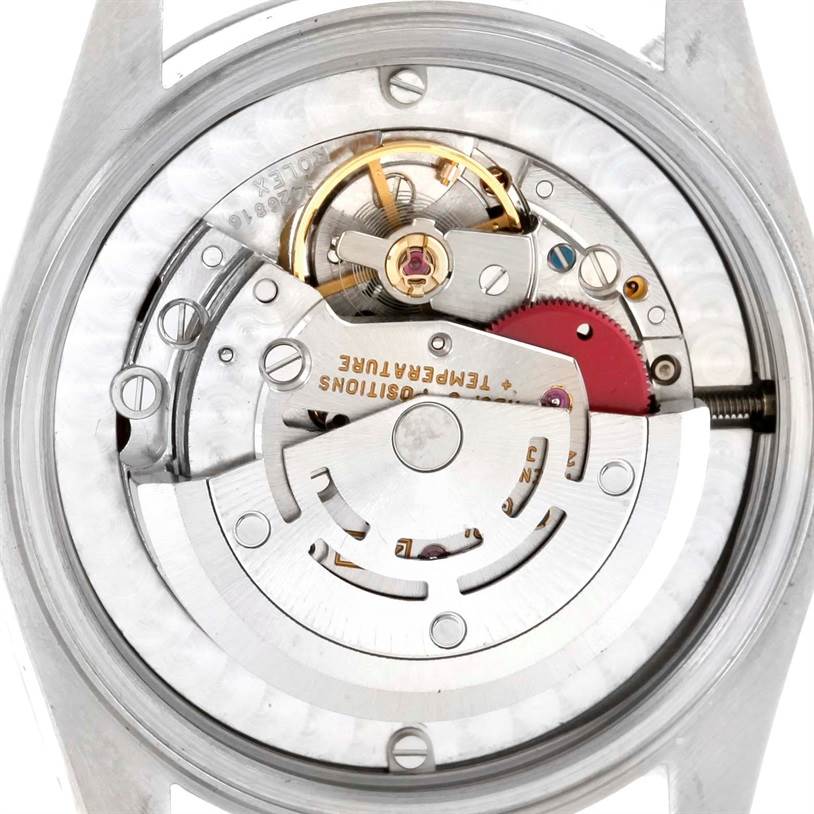 The image shows a close-up view of the movement mechanism of a Rolex Mid-Size 67480 Women's Stainless Steel Blue Dial 67480 Women's Stainless Steel Blue Dial watch, highlighting gears and components.