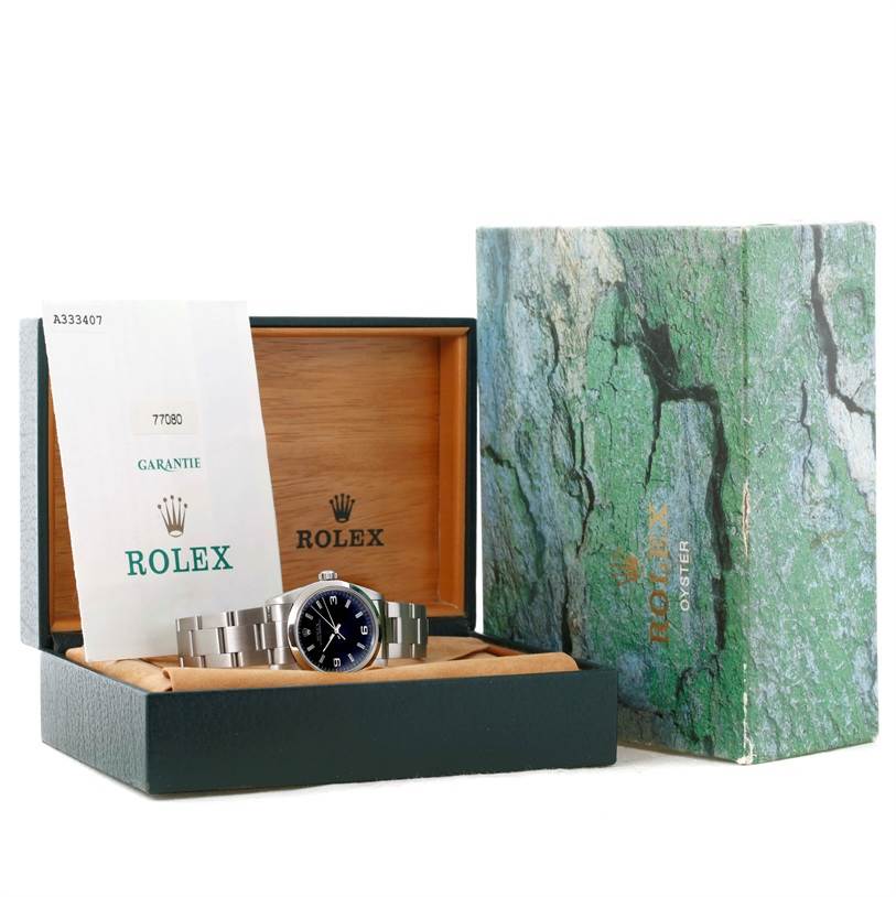 The Rolex Mid-Size 77080 Men
s Stainless Steel Black Dial 77080 Men
s Stainless Steel Black Dial watch and warranty card are displayed inside an open wooden box with the outer box placed beside it at an angle.