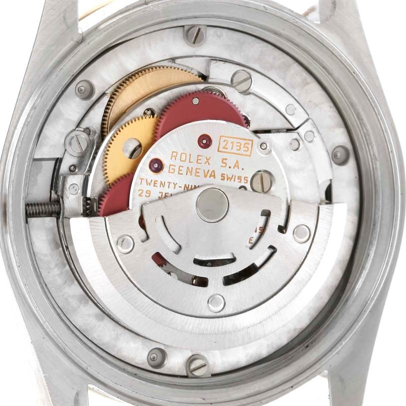 This image shows the internal mechanism of a Mid-Size Rolex watch, focusing on gears and the rotor.