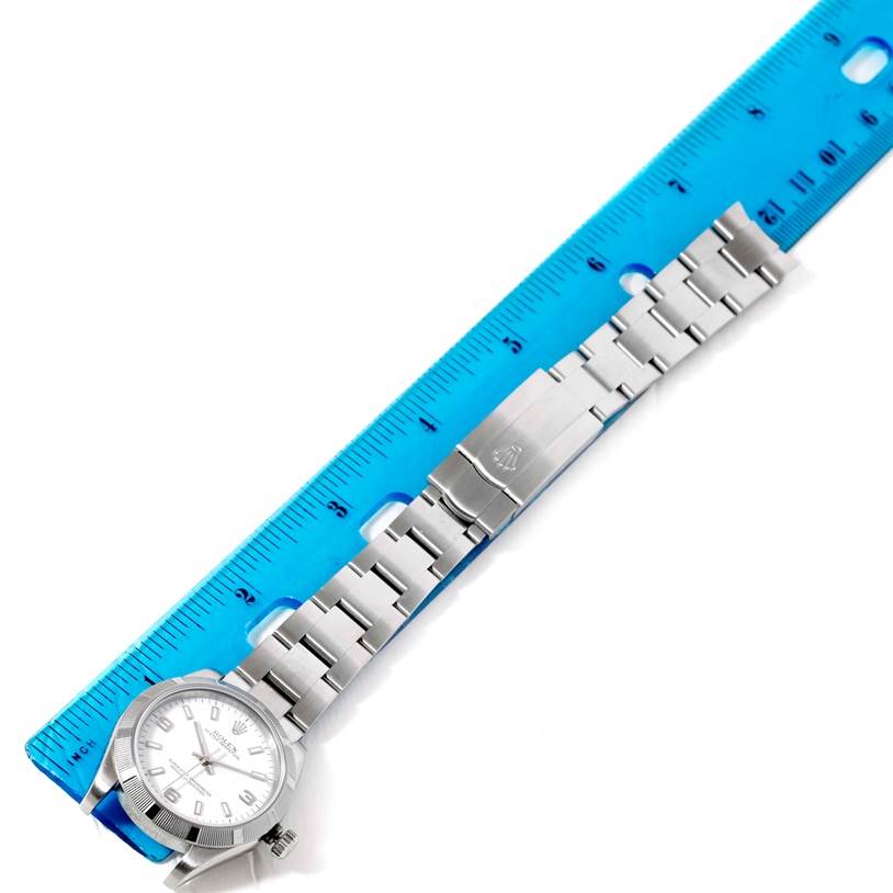 The image shows a Mid-Size Rolex watch laid flat with its bracelet extended and measured against a blue ruler.
