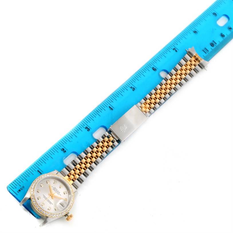 The image shows a Rolex Mid-Size 68273 Women's Steel and Gold (two tone) Silver Dial 68273 Women's Steel and Gold (two tone) Silver Dial watch placed next to a blue ruler, displaying its face, bezel, and bracelet.