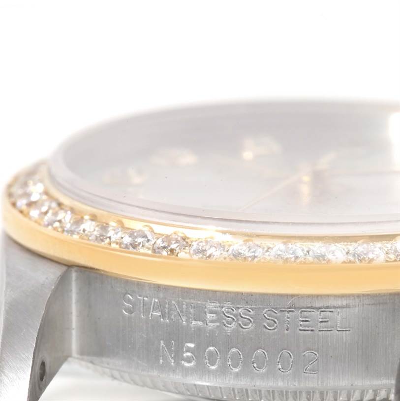 The image shows a close-up of a Rolex Mid-Size 68273 Women's Steel and Gold (two tone) Silver Dial 68273 Women's Steel and Gold (two tone) Silver Dial watch, focusing on its diamond bezel and stainless steel case with serial number engraving.