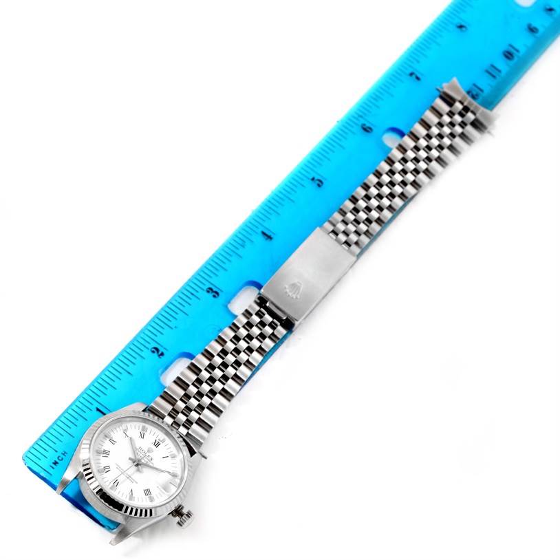 The Rolex Mid-Size 68274 Women's Stainless Steel White Dial 68274 Women's Stainless Steel White Dial watch is shown from a top-down angle, displaying the face, bracelet, and clasp alongside a blue ruler for scale.