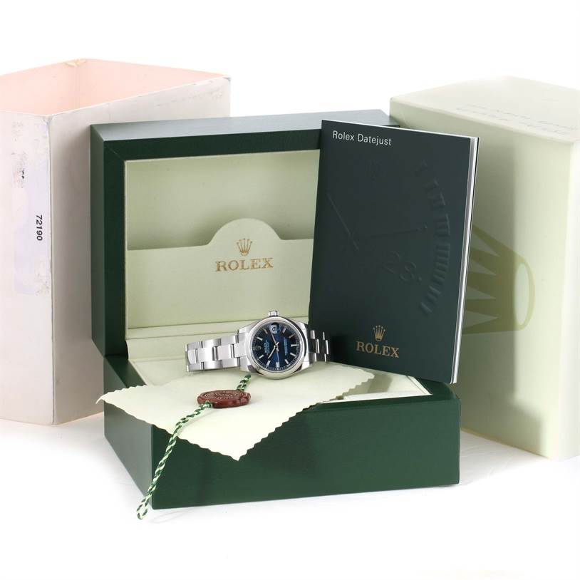 The image shows a Mid-Size Rolex watch displayed in an open green Rolex box, accompanied by booklets and accessories.