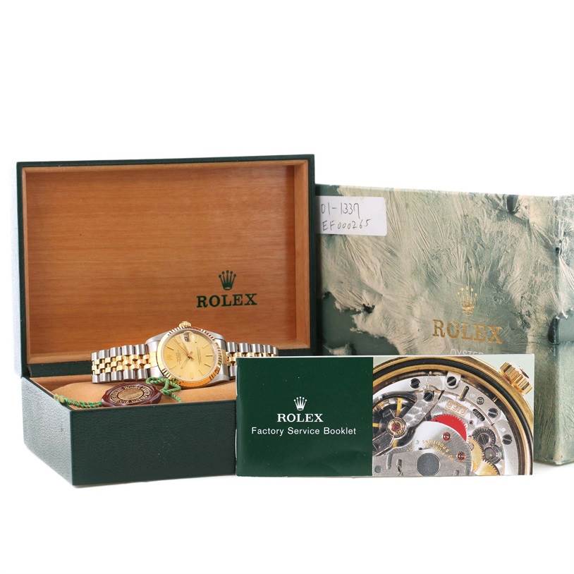 The image shows a Mid-Size Rolex watch in its box, along with a Rolex Factory Service Booklet and outer green packaging.