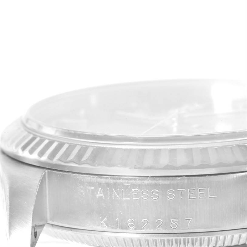 The image shows a close-up angle of the side of a Rolex Mid-Size 77014 Women's Stainless Steel Blue Dial 77014 Women's Stainless Steel Blue Dial model, highlighting the stainless steel case and engraving.