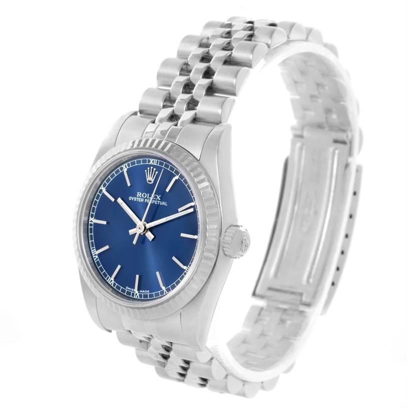 This Rolex Mid-Size 77014 Women's Stainless Steel Blue Dial 77014 Women's Stainless Steel Blue Dial model watch is shown at a slight angle, highlighting its blue dial, bezel, crown, and stainless steel bracelet.