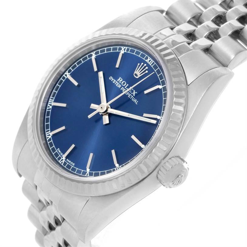 The image shows a close-up angled view of a Rolex Mid-Size 77014 Women's Stainless Steel Blue Dial 77014 Women's Stainless Steel Blue Dial Oyster Perpetual watch, highlighting the blue dial, bezel, and part of the bracelet.