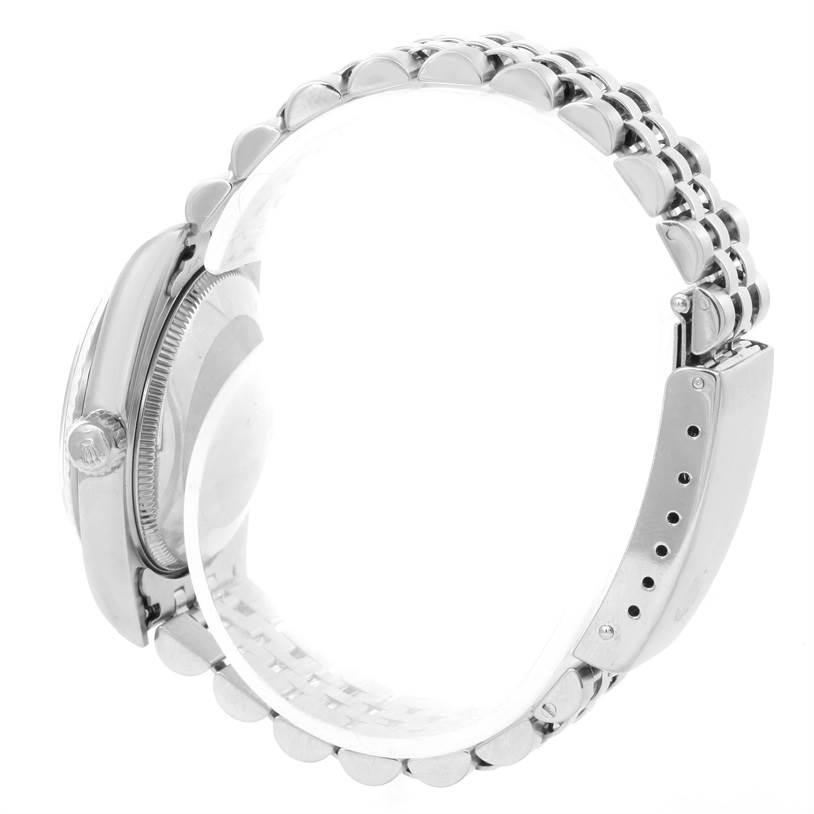 This side view of the Rolex Mid-Size 77014 Women's Stainless Steel Blue Dial 77014 Women's Stainless Steel Blue Dial model shows the watch case, crown, and part of the metal bracelet.