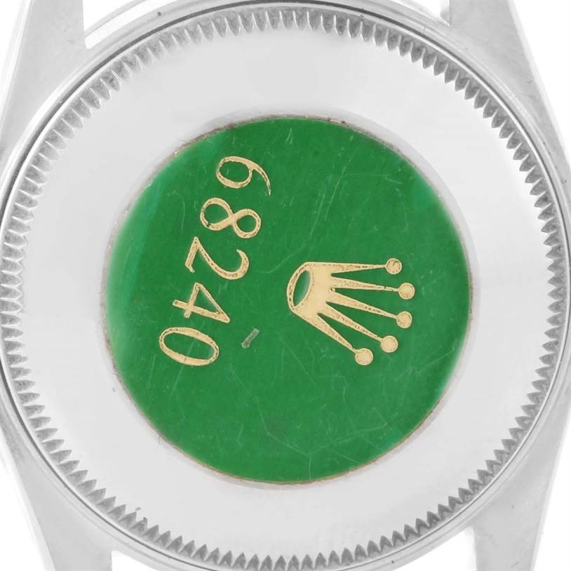 This image shows the back case of a Rolex Mid-Size 68240 Women's Stainless Steel Blue Dial 68240 Women's Stainless Steel Blue Dial model watch, focusing on the green sticker with model number 68240 and the brand logo.