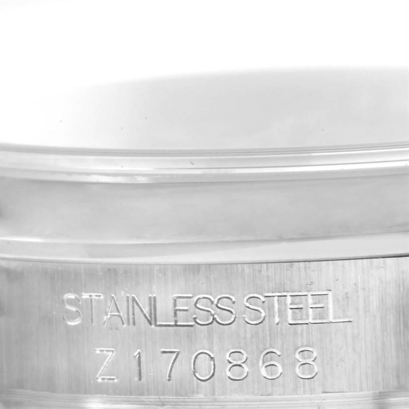 This image shows a close-up of the case side of a Rolex Mid-Size 178240 Women's Stainless Steel Blue Dial 178240 Women's Stainless Steel Blue Dial model, highlighting the "STAINLESS STEEL" engraving and serial number.