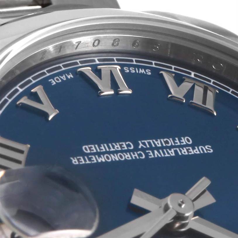 This close-up image shows the dial and part of the case of a Mid-Size Rolex watch, highlighting the Roman numeral indices and the bezel's edge.