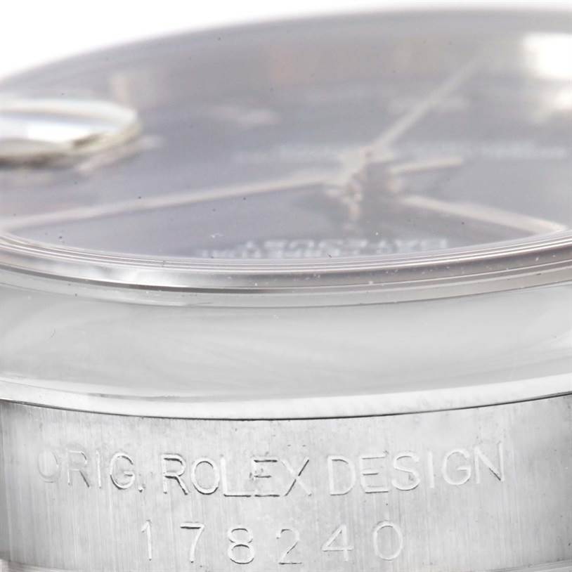 The image shows a close-up of the Rolex Mid-Size 178240 Women's Stainless Steel Blue Dial 178240 Women's Stainless Steel Blue Dial watch's bezel and engraved case side.