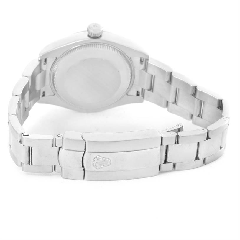 The image shows the back view of a Mid-Size Rolex watch, highlighting its case back, crown, and bracelet with the clasp.