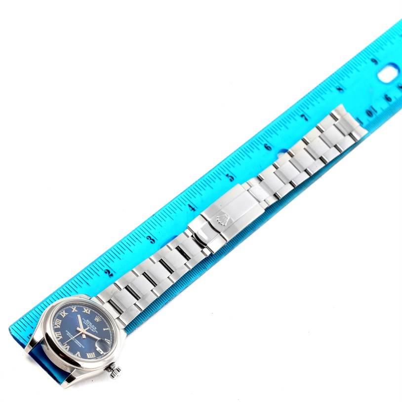 The image shows a Rolex Mid-Size 178240 Women's Stainless Steel Blue Dial 178240 Women's Stainless Steel Blue Dial watch laid flat next to a blue ruler, displaying the watch face and stainless steel bracelet.