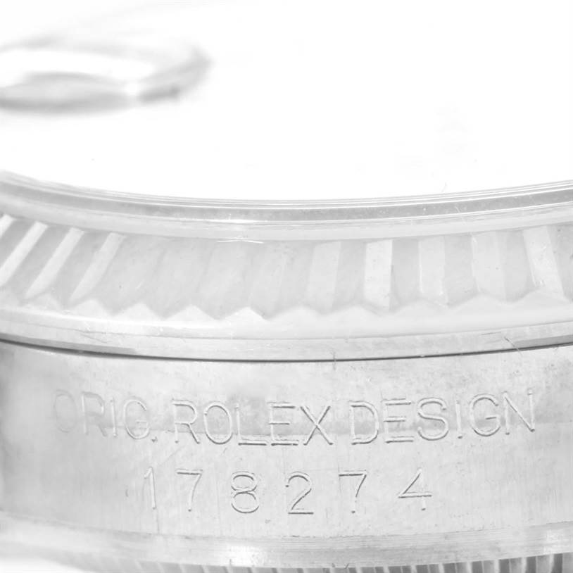 This close-up image shows the side of the bezel and case of a Mid-Size Rolex watch, displaying the engraved serial number.
