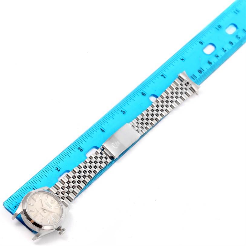 The Rolex Mid-Size 68240 Women's Stainless Steel Silver Dial 68240 Women's Stainless Steel Silver Dial watch is shown from a top-down angle, displaying the face, bracelet, and clasp beside a ruler for scale.