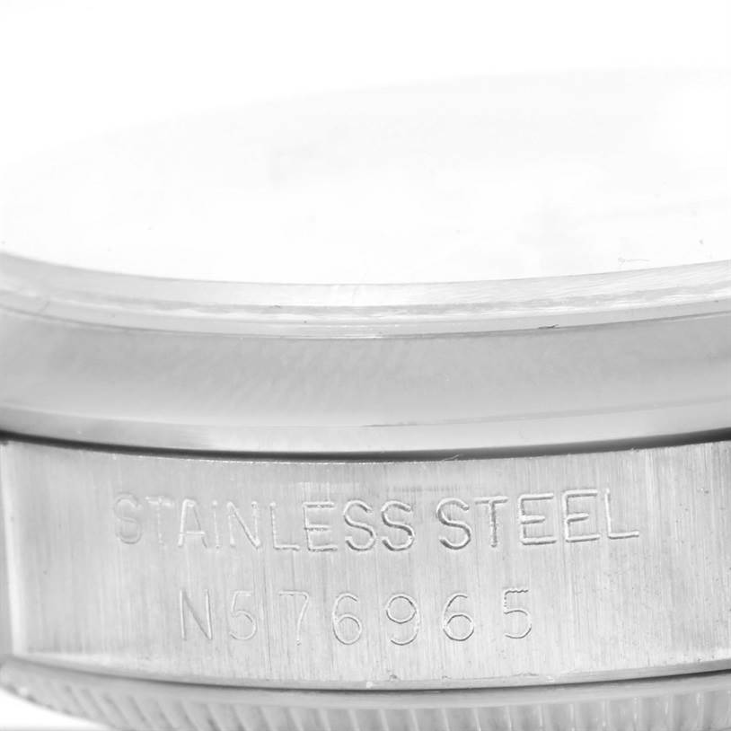 This image shows a close-up of the stainless steel case back and serial number of a Mid-Size model Rolex watch.