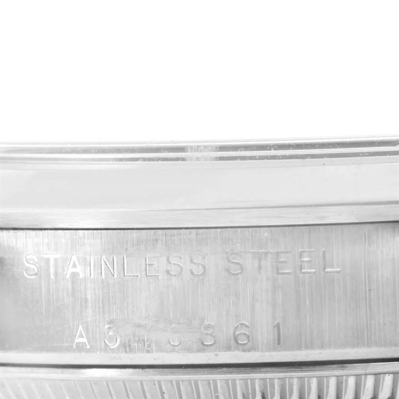 This image shows a close-up of the case back and outer edge of a Mid-Size Rolex watch, revealing the "STAINLESS STEEL" engraving and serial number.