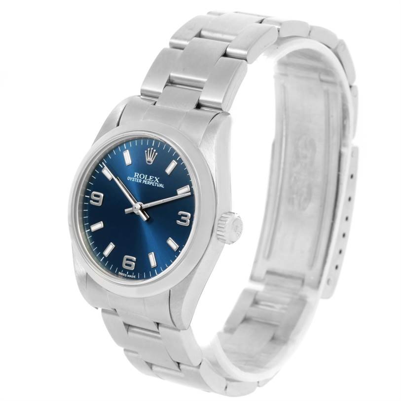 This image shows a Rolex Mid-Size 77080 Women's Stainless Steel Blue Dial 77080 Women's Stainless Steel Blue Dial Oyster Perpetual watch angled from the front and slightly to the right, displaying the face, bezel, and part of the bracelet.
