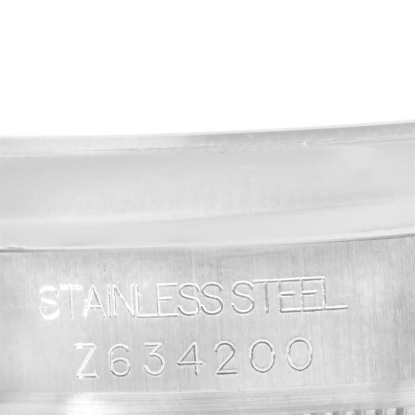 This close-up image shows the serial number and "STAINLESS STEEL" engraving on the mid-size Rolex watch's case.