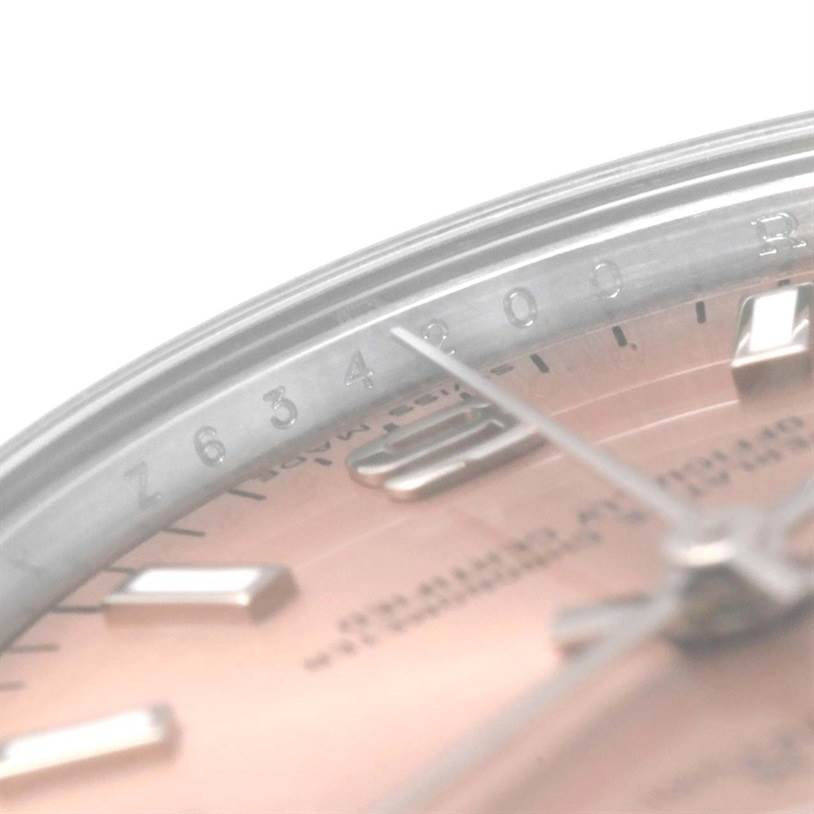 This close-up image of the mid-size Rolex watch focuses on part of the bezel, dial, and a portion of the minute hand.