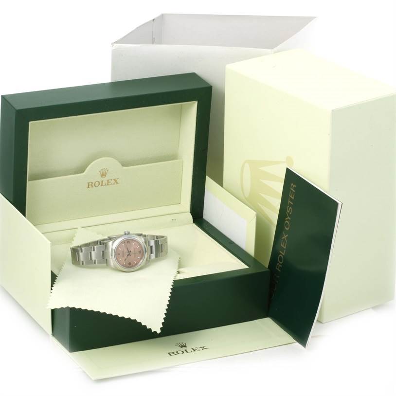 The image shows an open box containing a Mid-Size Rolex watch with a booklet and cleaning cloth, viewed from the front angle.