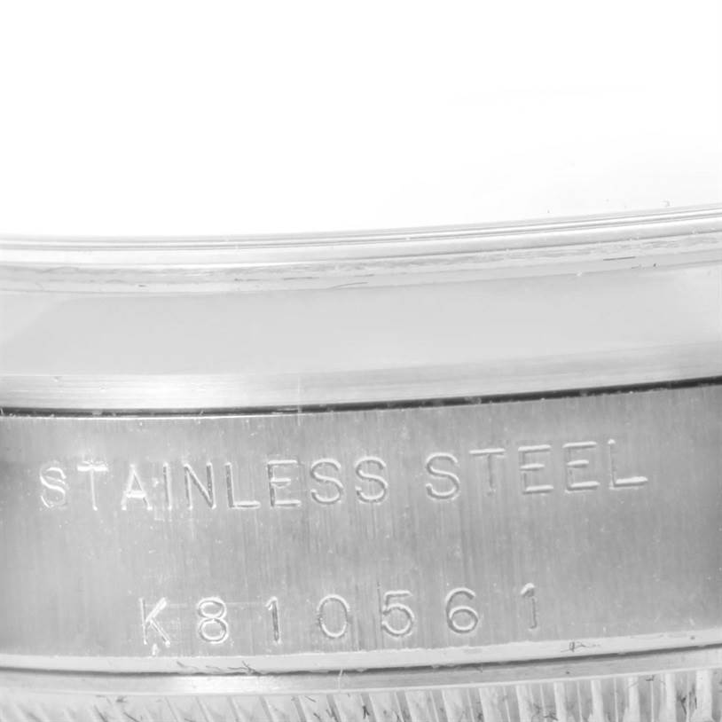 The image shows a close-up of the case and rim of a Mid-Size Rolex watch, highlighting the stainless steel material and serial number.