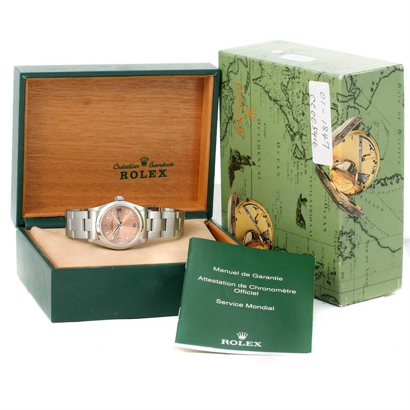 This shot shows a Mid-Size Rolex watch centered inside its open case with the original box and manuals around it at a slight right angle.